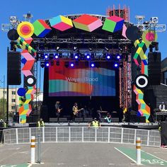 the stage is set up for an outdoor concert with bright colored lights and colorful decorations