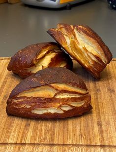 two loaves of bread sitting on top of a cutting board