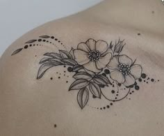 the back of a woman's shoulder with flowers on it