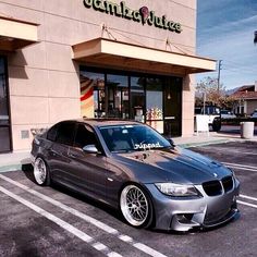 a silver car parked in front of a store