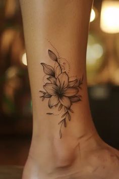 a woman's foot with a flower tattoo on the side of her leg,