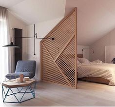 a room with a bed, chair and wooden slatted door in the corner