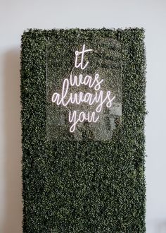 a sign that says it was always you on the side of a green plant wall