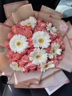 a bouquet of pink roses and white daisies