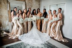 a group of women standing next to each other in front of a mirror holding bouquets