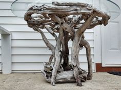 a table made out of driftwood and glass top