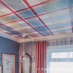 a bedroom with red, white and blue plaid painted on the ceiling is pictured in this image