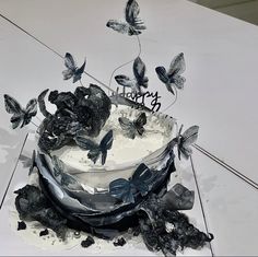 the cake is decorated with butterflies and frosting