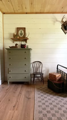 an old dresser and chair in a small room