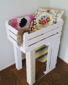 a white bench with two pillows on top of it and a pillow in the middle