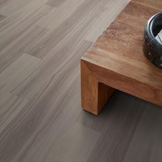 a close up of a wooden table with a bowl on it and a vacuum in the middle