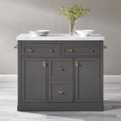 a kitchen island with marble top and two bowls on the counter, in front of a gray wall