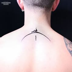 the back of a man's neck with a small tattoo on his left side