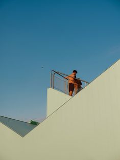 a man riding a skateboard down the side of a metal rail on top of a building