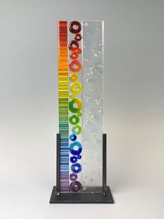 a tall glass sign with the word cococo written in rainbow letters on it's side