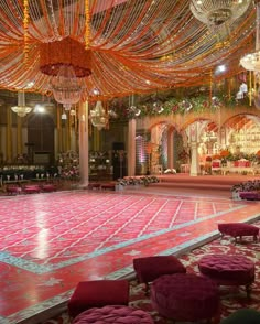 an elaborately decorated ballroom with chandeliers and pink velvet seatings on the dance floor