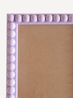 a close up of a frame made out of plastic balls and beads on a white background