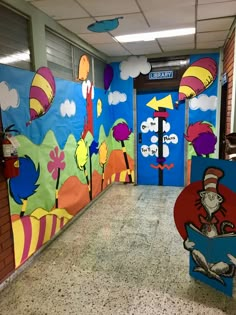 the cat in the hat themed hallway is decorated with blue and green walls, red doors, and colorful dr seuss posters