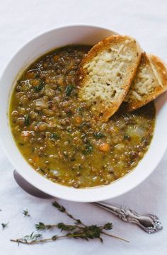 a white bowl filled with soup and two pieces of bread