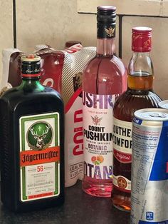 several different types of alcohol sitting on a counter next to each other, including rum