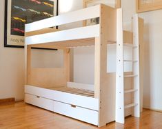 a white bunk bed sitting on top of a hard wood floor