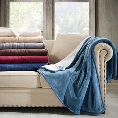 a couch with several blankets stacked on top of it