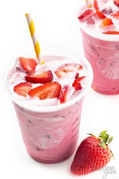 two cups with strawberries and ice cream in them on a white surface next to one another