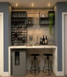 a bar with two stools in front of it and wine bottles on the wall