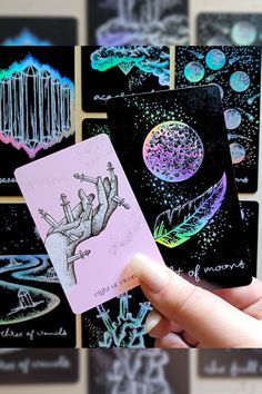 a hand holding up some cards with different designs on them and an image of a person's hand in the background