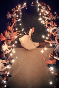 the bride and groom are surrounded by sparklers