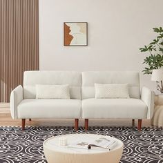 a living room with white couches and black and white rugs on the floor