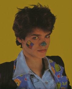 a man with his face painted in the colors of the rainbow