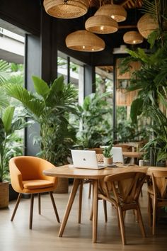 a laptop computer sitting on top of a wooden table in front of potted plants