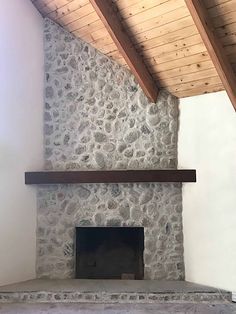 a stone fireplace in a room with wood beams