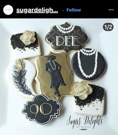 some decorated cookies on top of a white plate with black and gold decorations in the middle