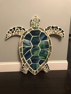 a sea turtle made out of mosaic tiles on the wall in front of a door