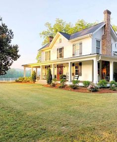 a large white house sitting on top of a lush green field