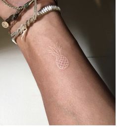 a woman's arm with a pineapple tattoo on it