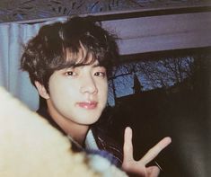 a young man making the peace sign with his hand