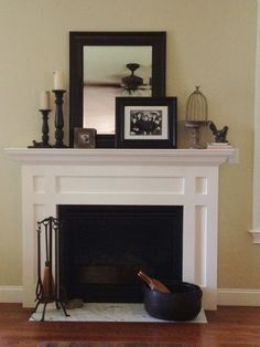 a white fireplace with a mirror above it