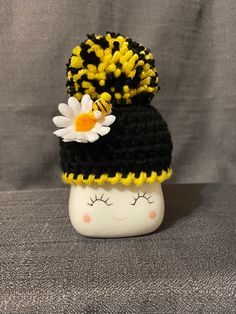 a small black and yellow hat with flowers on it