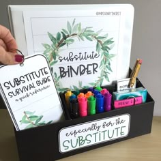 a black box with markers and pens in it on a table next to a sign that says substitue survival guide