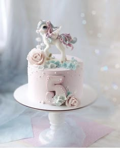 there is a pink cake with a white horse on top