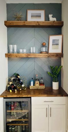 a wine cooler in the corner of a room with shelves above it and pictures on the wall