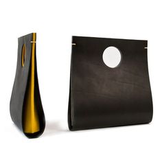 a black and gold vase sitting next to a brown bag