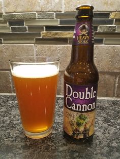 a bottle and glass sitting on a counter