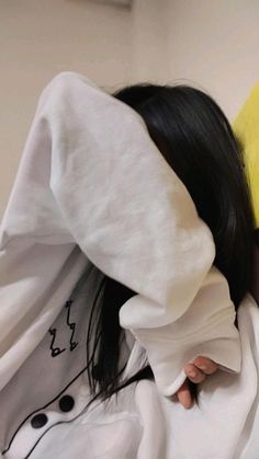 a person with a banana on their head covering her eyes and holding the hood up