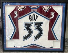 a hockey jersey is displayed in a black frame