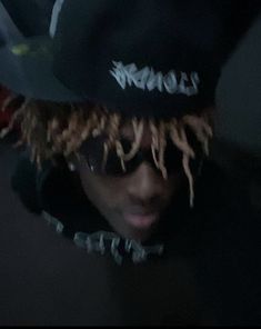 a man with dreadlocks and a hat is seen through the lens of another person's head