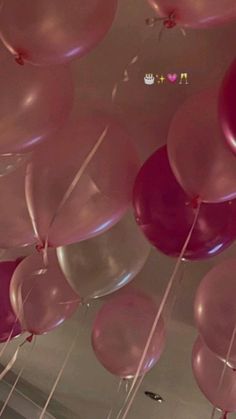 pink and silver balloons are hanging from the ceiling